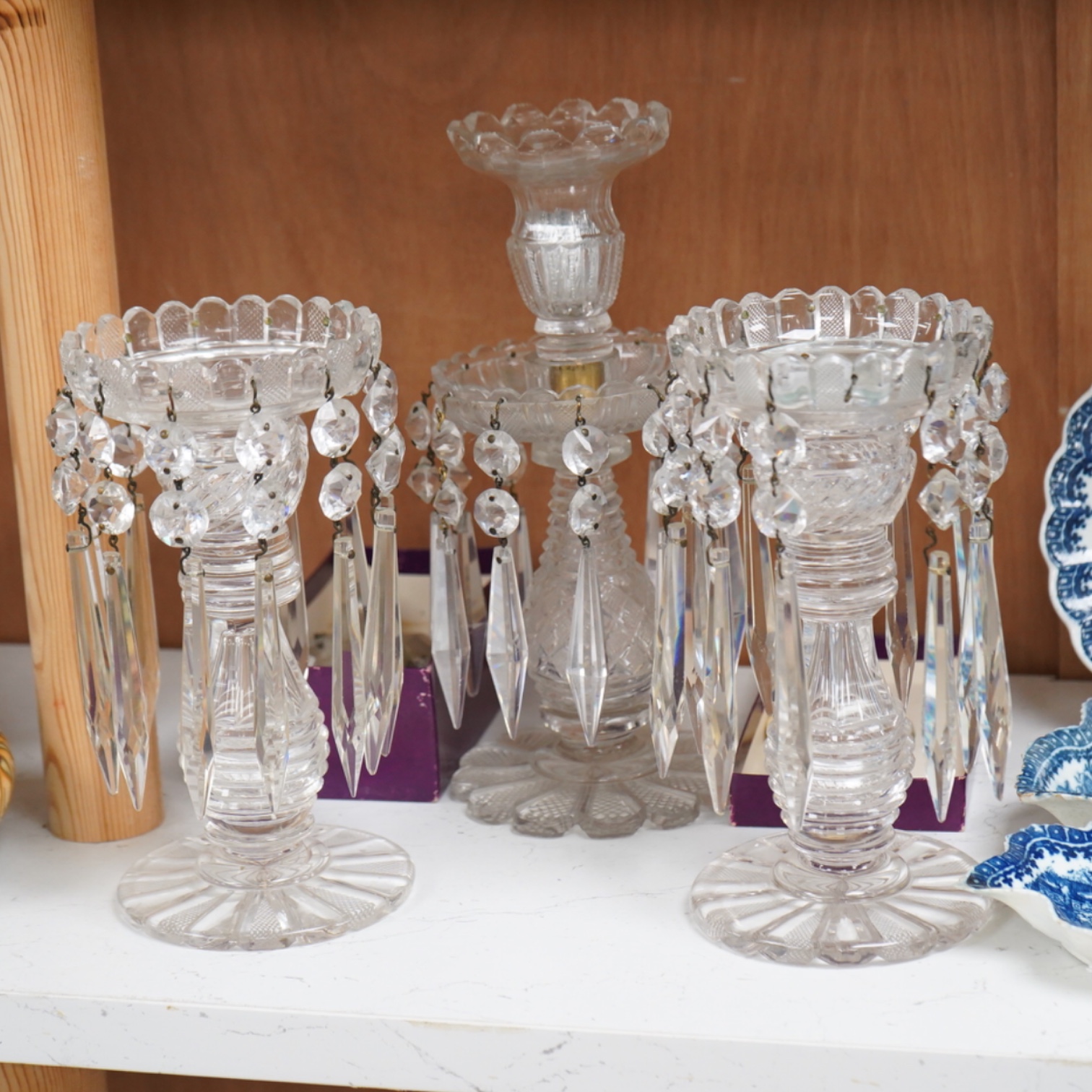 A pair of Victorian cut glass lustre candlesticks and one larger candlestick, 24cm high